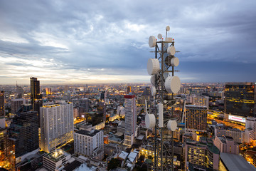 Telecommunication tower with 5G cellular network antenna on night city background