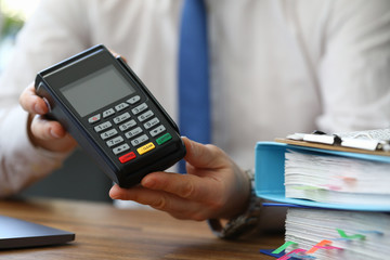 Close-up view of male showing and recommend modern device for payments using plastic credits. Contactless pay via mobile phone or cards. Technology concept