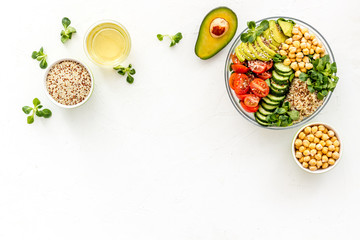 Healthy salad bowl with quinoa, avocado and chickpeas on white background top-down copy space