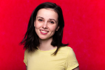 beautiful girl in a yellow t-shirt on a red background