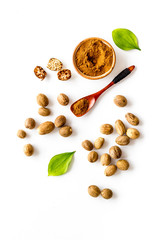 Nutmeg - ground indian condiment in spoon - on white background top-down