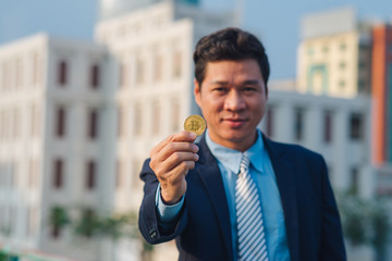 Golden bitcoin in hand of business man with black suit