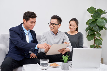 Sales Consultant showing new investment plans to young asian couple