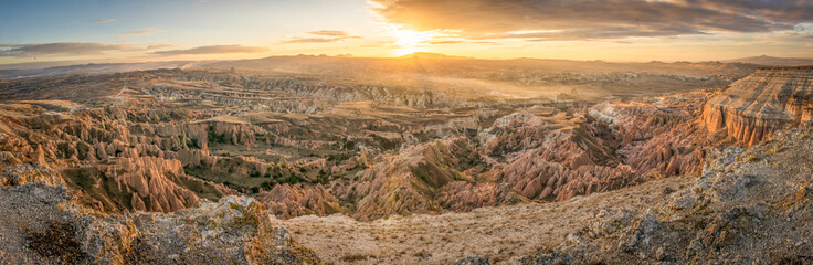Panoramic soft dramatic sunrise over the red and rose valleys with aeial view down from canyon....