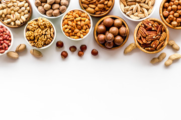 Set of macadamia, hazelnut, walnut, almond, pistachio, pecans nuts on white background top-down frame copy space