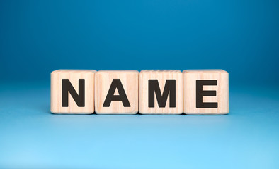 Fototapeta premium NAME - text on wooden blocks, concept, blue background