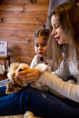 vertical photo of a young woman with a six year old daughter and their funny dog