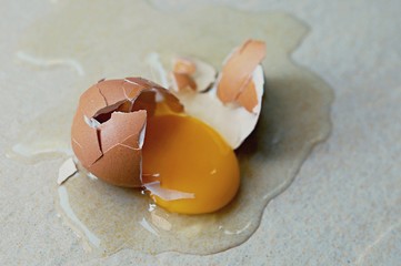 ฺBroken egg on the floor with copy space. Selective focus. This photo can be used for the concept...