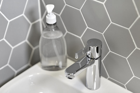 Hygiene, Hand Wash And Household Concept - Close Up Of Water Tap With Liquid Soap On Sink Bathroom