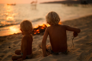 children by the fire on the shore