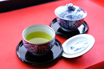 毛氈の上に置かれた蓋つきの湯飲みで緑茶を頂く