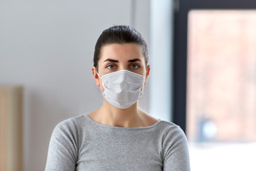 health, safety and pandemic concept - young woman wearing protective medical mask