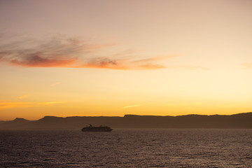 Naklejka na ściany i meble Photo of a cruise ship at sunset shot on March 2020