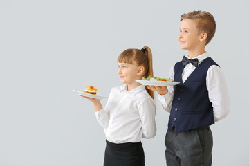 Cute little waiters on light background