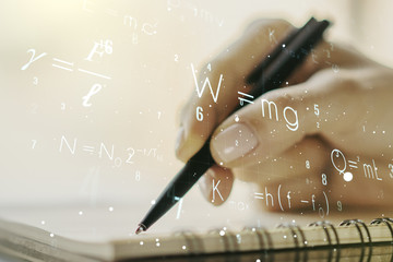 Creative scientific formula hologram with woman hand writing in notepad on background, research concept. Multiexposure