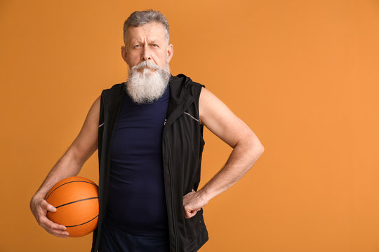 Elderly basketball player on color background