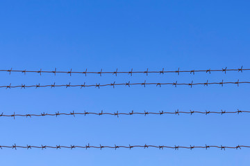 Barbed wire against a blue sky background