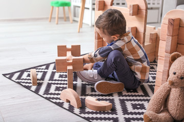 Fototapeta na wymiar Little boy playing with take-apart house at home