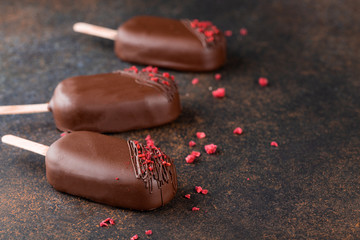 Milk chocolate popsicles decorated dried raspberries. Dessert. Popsicles.
