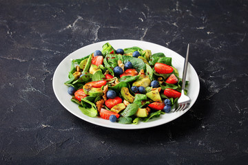 spinach avocado walnuts salad on a plate