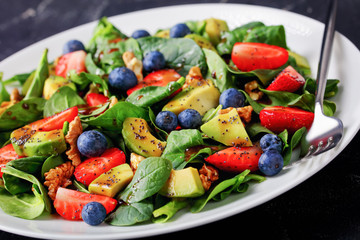 spinach avocado walnuts salad on a plate