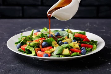 Tafelkleed dressing is pouring over fresh spinach salad © myviewpoint