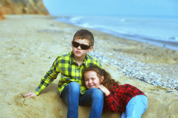 Brother and sister on a walk along the sea on a spring day