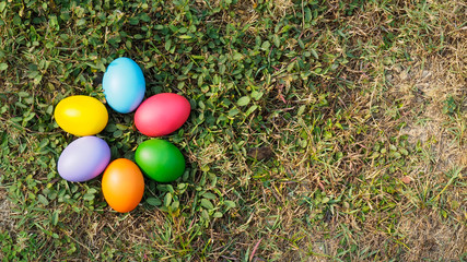 Easter eggs in many colors on the grass. Red egg, blue egg, yellow egg