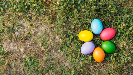 Easter eggs in many colors on the grass. Red egg, blue egg, yellow egg
