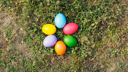 Easter eggs in many colors on the grass. Red egg, blue egg, yellow egg