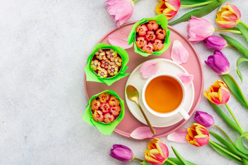 A cup of tea with tulips on white background