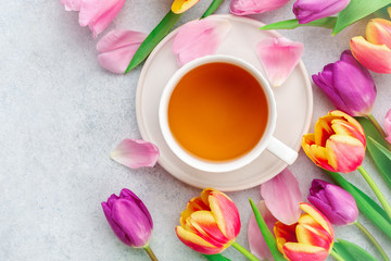 Fototapeta na wymiar A cup of tea with tulips on white background