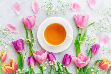 A cup of tea with tulips on white background