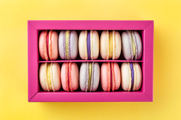 Colorful macaroons and flowers. Sweet macarons in gift box. Top view