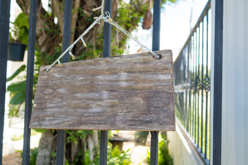 Wooden sign hanging in front of the fence