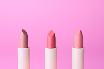 Different lipsticks on color background