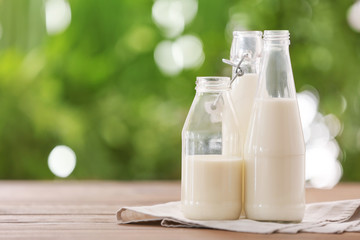 Bottles of fresh milk on table outdoors