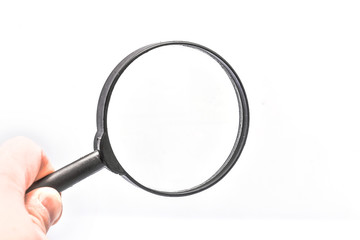Close-up holding a magnifying glass on a white background.