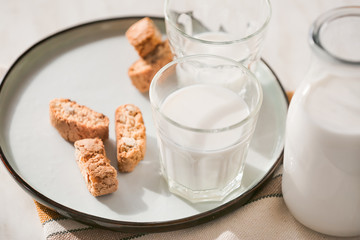 Glassware of fresh milk and cookies on table