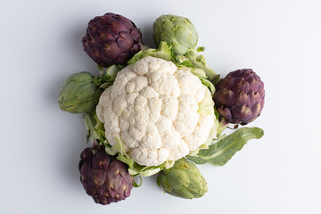 Still life with artichokes and a cauliflower over white background