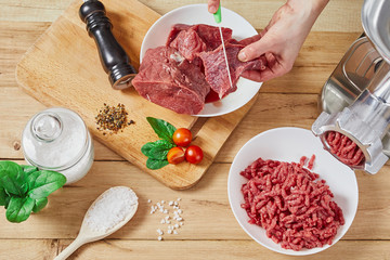 Chopped raw meat and ground beef . The process of preparing forcemeat by meat grinder. Top view.