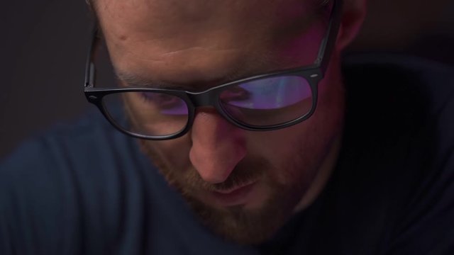 Reflection in Men's Glasses. Office routine, a man writes in slow motion
