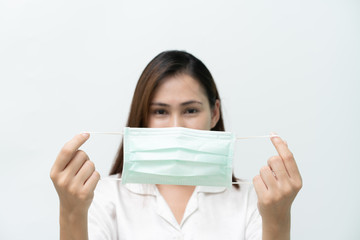 Fototapeta premium White shirt, woman looked at a medical mask to prevent the flu and the Covid-19 coronary virus, focus on the mask