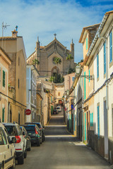 Naklejka premium Empty street in Arta with Transfiguracio del Senyor church in the background - Mallorca, Spain
