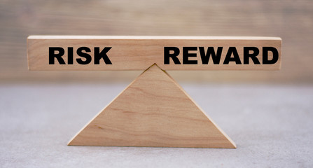 balance concept on wooden RISK on a REWARD wooden background