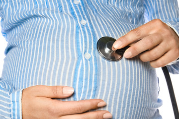 Fototapeta premium Happy pregnant girl with a statoscope in hands on a white background