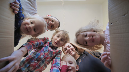 A large family opens the box in their home.