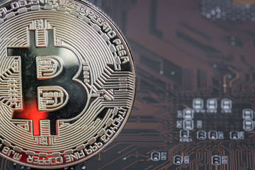 Golden silver crypto currency coin on motherboard. Shiny closeup crypto-currency coin background. Electronic money, cryptocurrency.