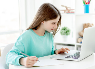 Cute girl studying at laptop