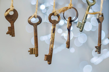 Old rusty keys hanged on the ropes with blurred lights bokeh background